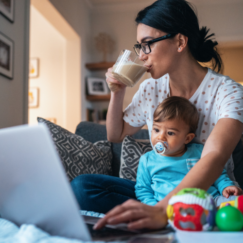Mom working on computer with child on lap