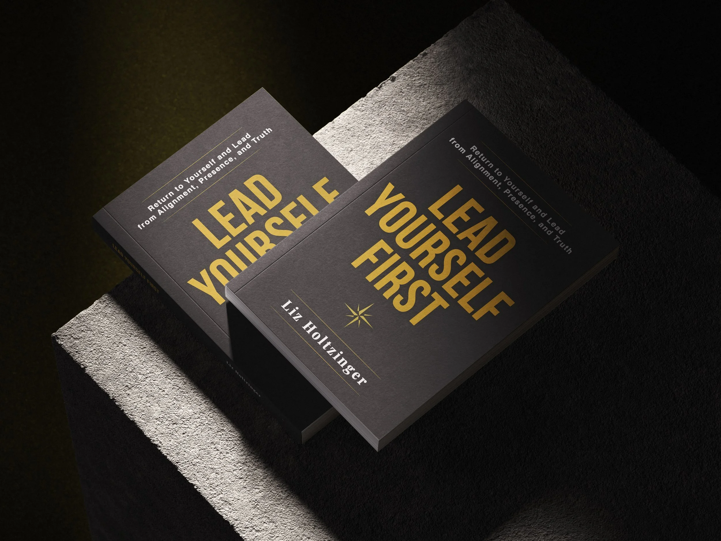 A black book titled 'Lead Yourself First' by Liz Holtzinger on a textured, light-colored surface with a dark background.