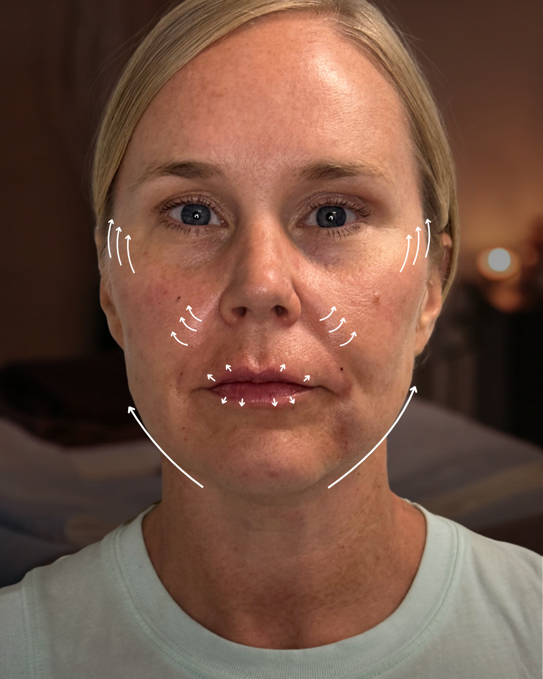 Close-up of a woman's face with outlined arrows indicating directions for facial massage or skincare application at Rejuvenate Wellness in Florence Kentucky