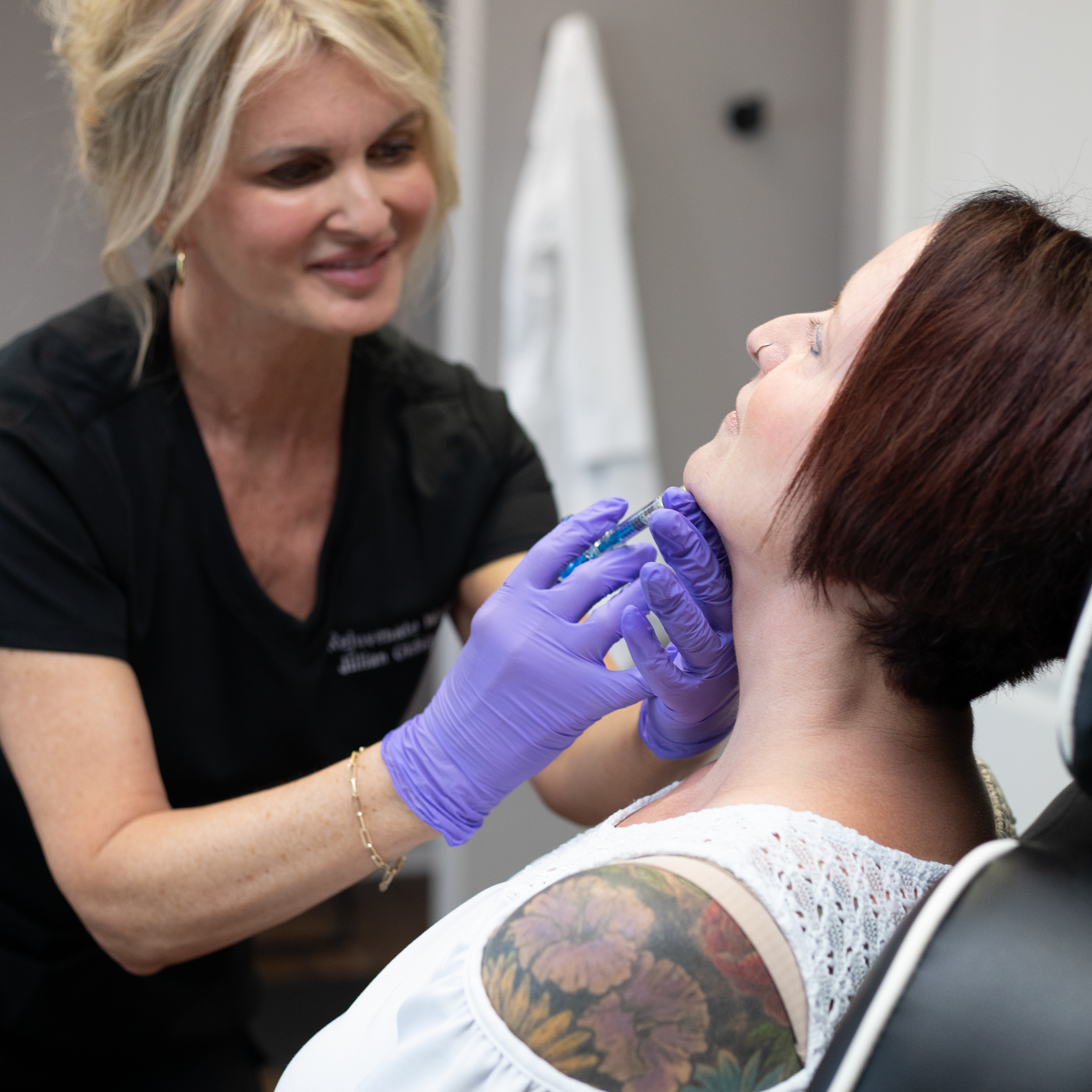 Medical professional administering a shot to a patient with visible tattoos on the patient's arm at Rejuvenate Wellness in Florence Kentucky