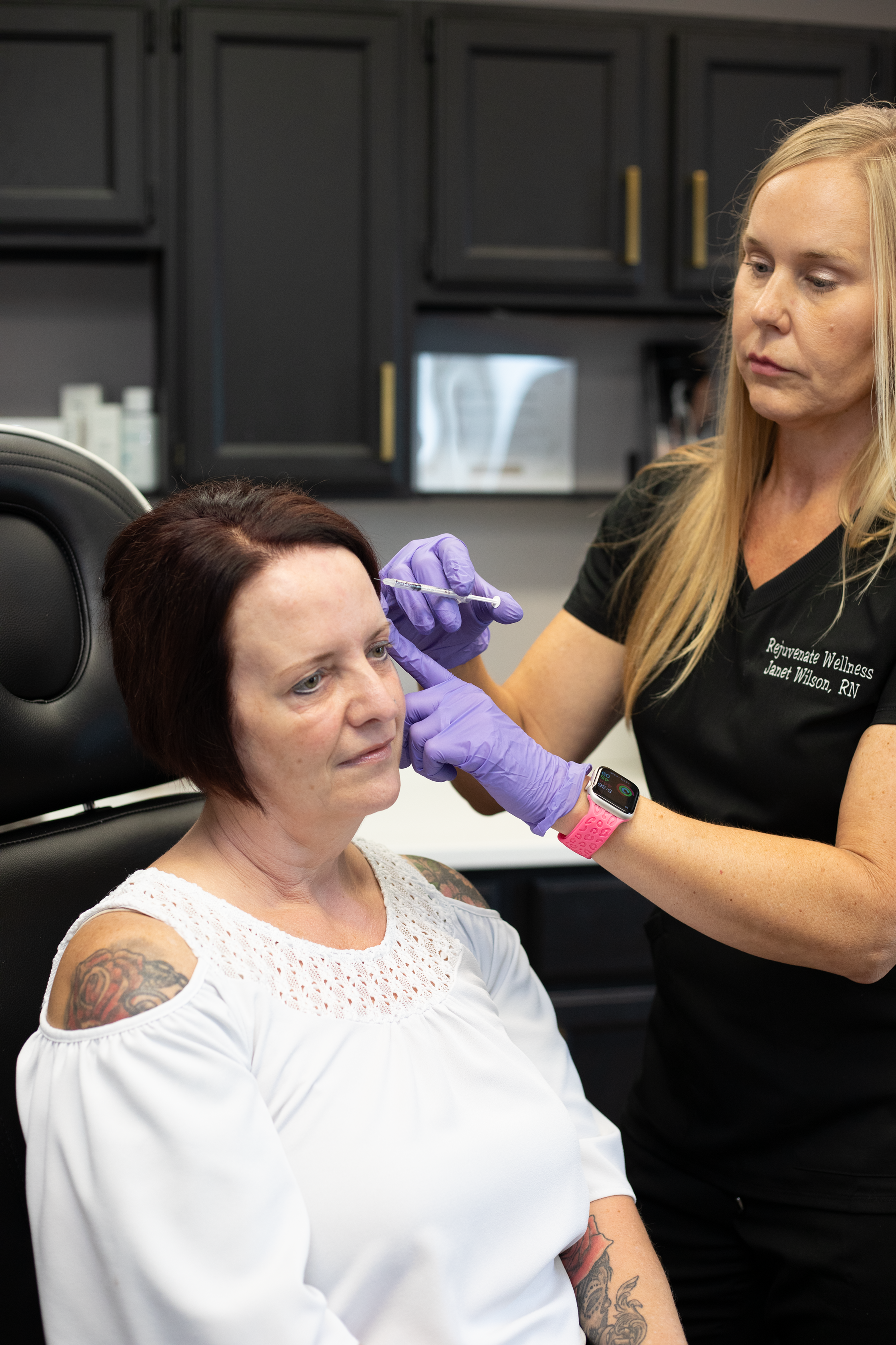 A woman receiving a facial injection from a nurse in a clinical setting at Rejuvenate Wellness in Florence Kentucky