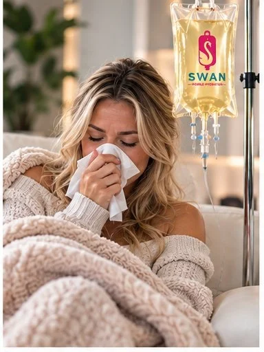 A woman with blonde hair sitting in bed, sneezing into a tissue, with a swan-shaped IV drip hanging beside her.