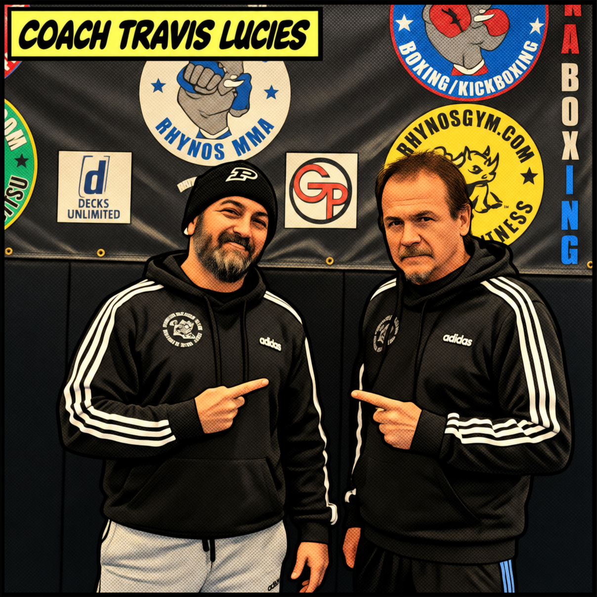 Two men standing in front of a black banner with various fitness and MMA logos. Both men are dressed in black Adidas hoodies with white stripes. The man on the left has a beard, is wearing a black beanie, and is pointing at the logo on his chest. The man on the right has short hair, a goatee, and is also pointing at the logo on his hoodie. The banner behind them features logos for Coach Travis Lucies, Rhynos MMA, Rhynos Gym, and other fitness organizations.