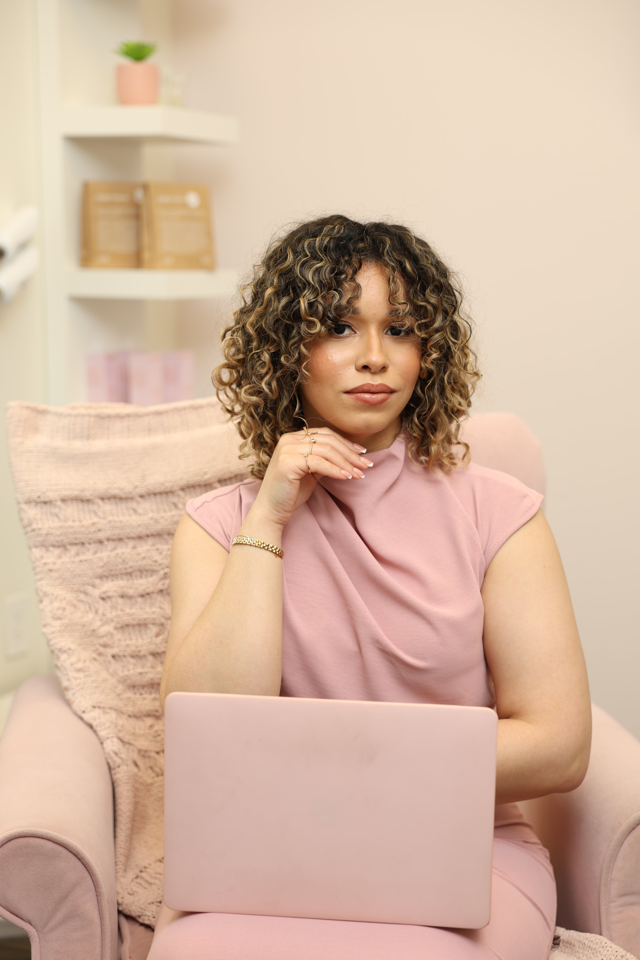Waxing professional at Wax Reveal by Carmen seated with a laptop inside the studio