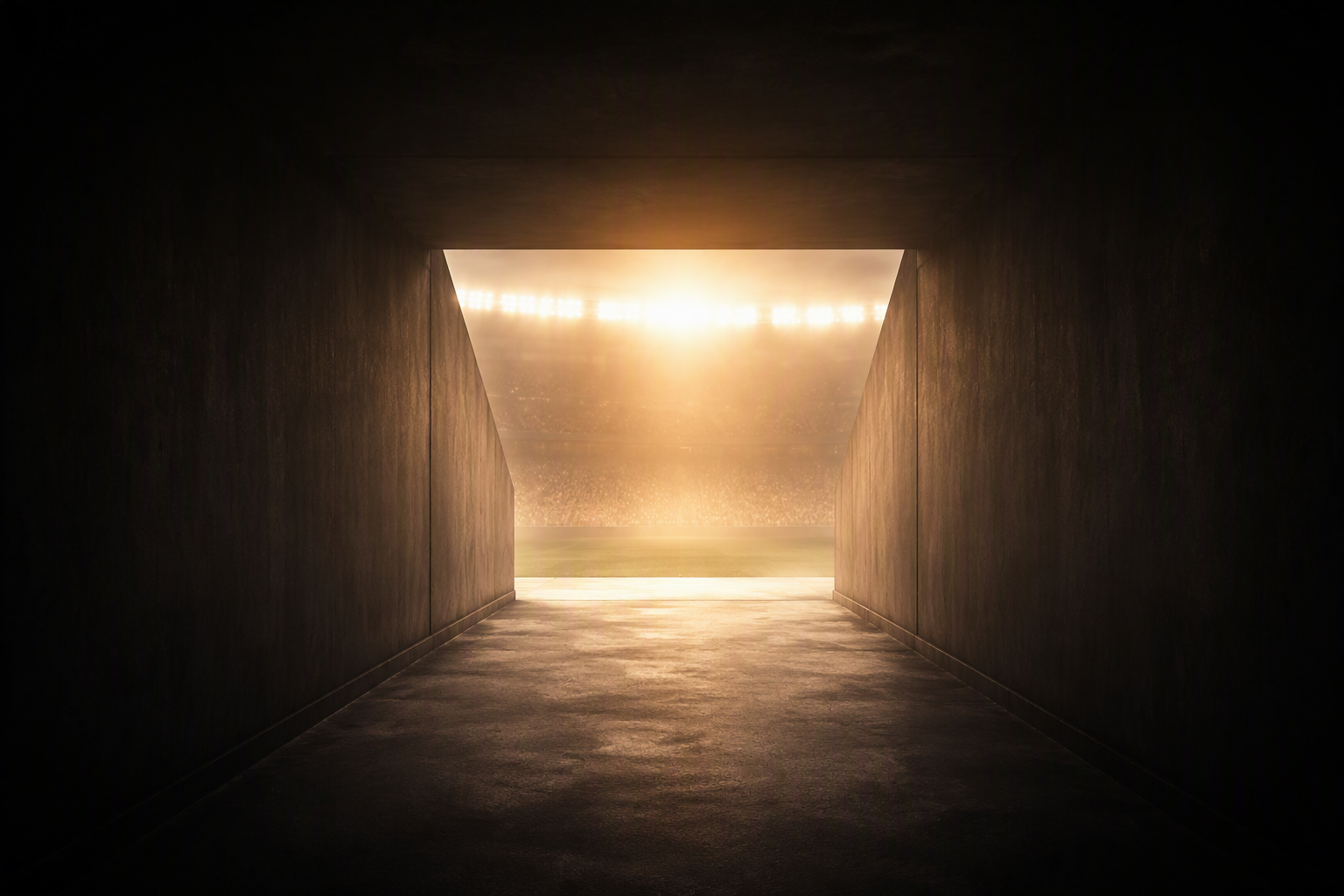 View from tunnel looking onto a brightly lit sports stadium with floodlights shining overhead.