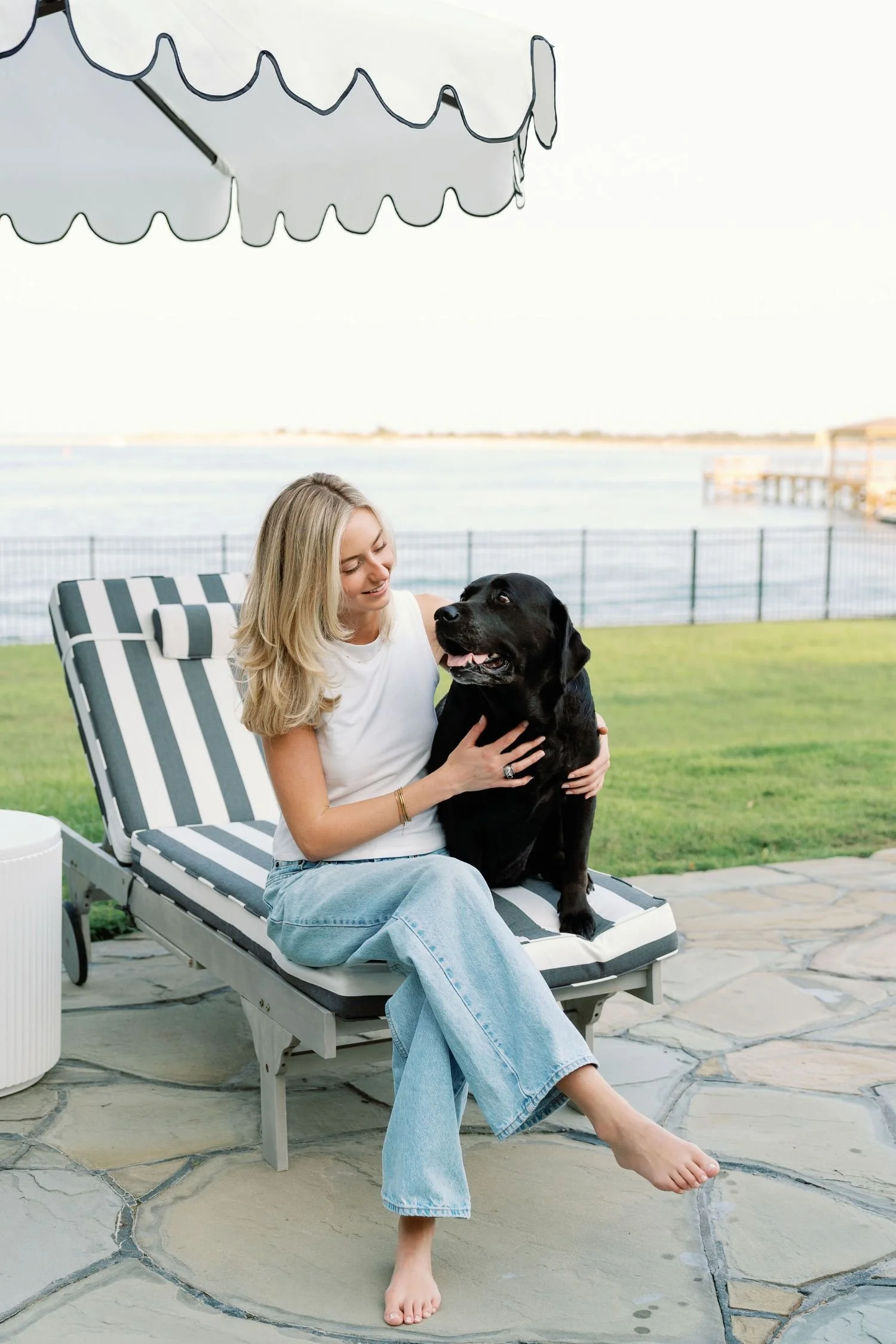 Woman smiling and holding a black dog