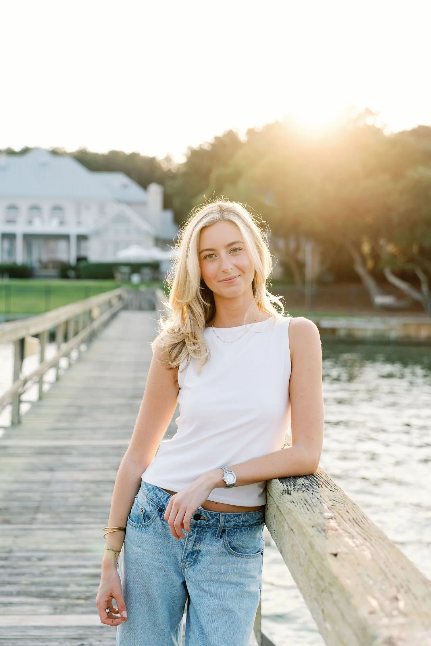 Woman smiling and leaning on a dock over the water