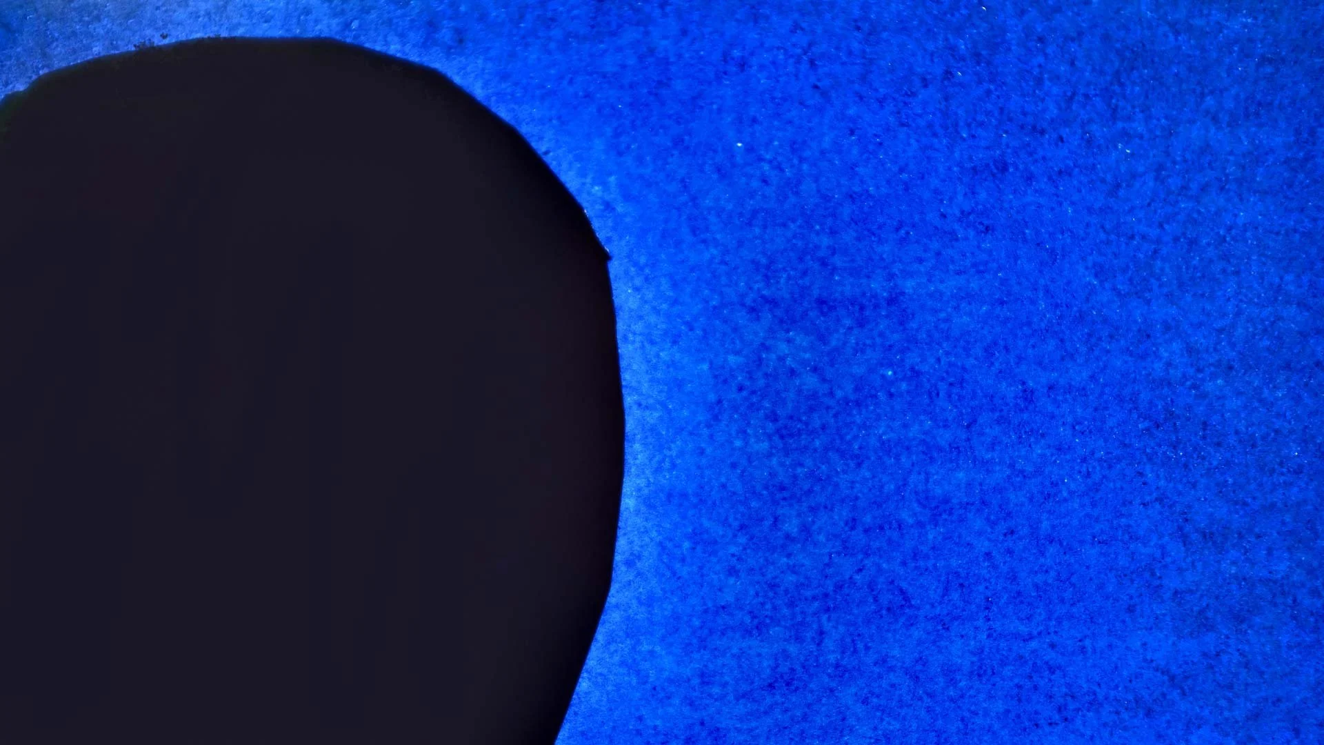 In the film's abstract visual language, circles stand for people: here a dark circle edges into a field of textured blue — All These Sons.