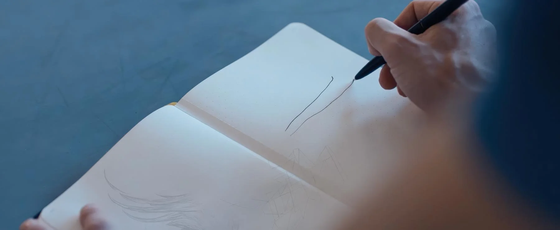 Pontus Lidberg draws two pencil lines in an open sketchbook — The Shimmering Asphalt, New York City Ballet.