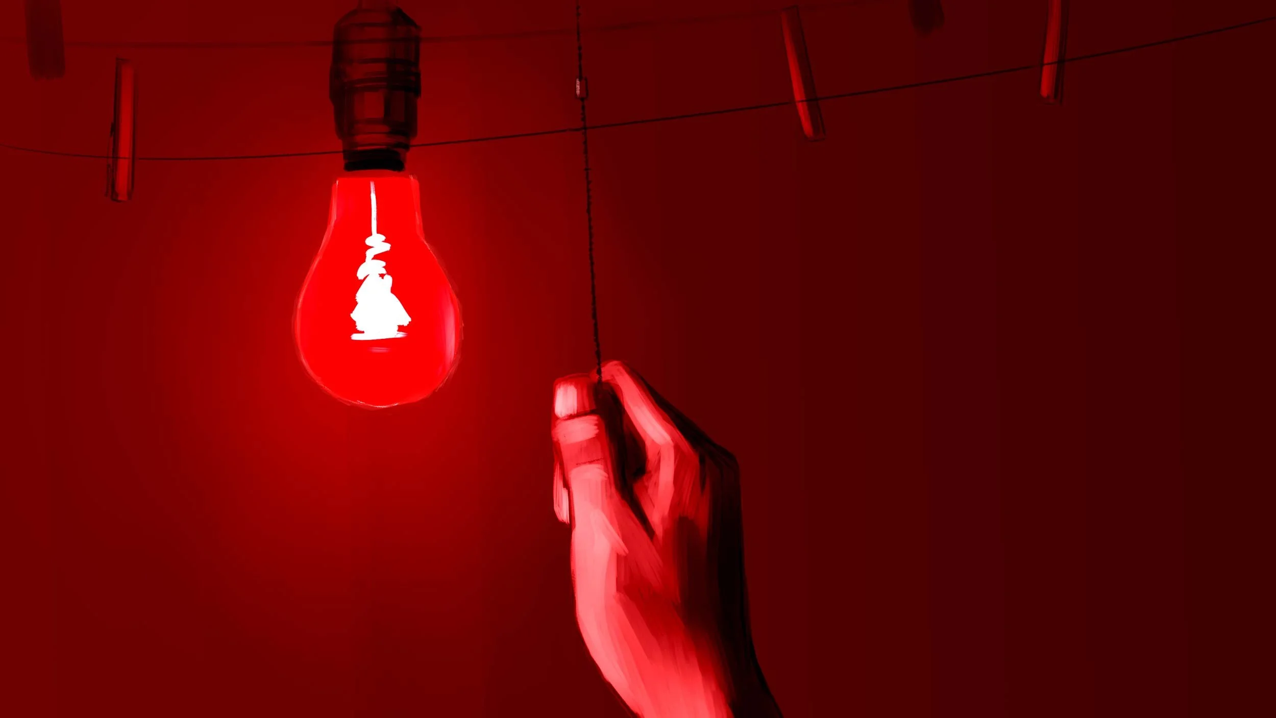 In his darkroom, Kailash's hand pulls the cord of a red safelight to develop photos of the raid — The Price of Free.