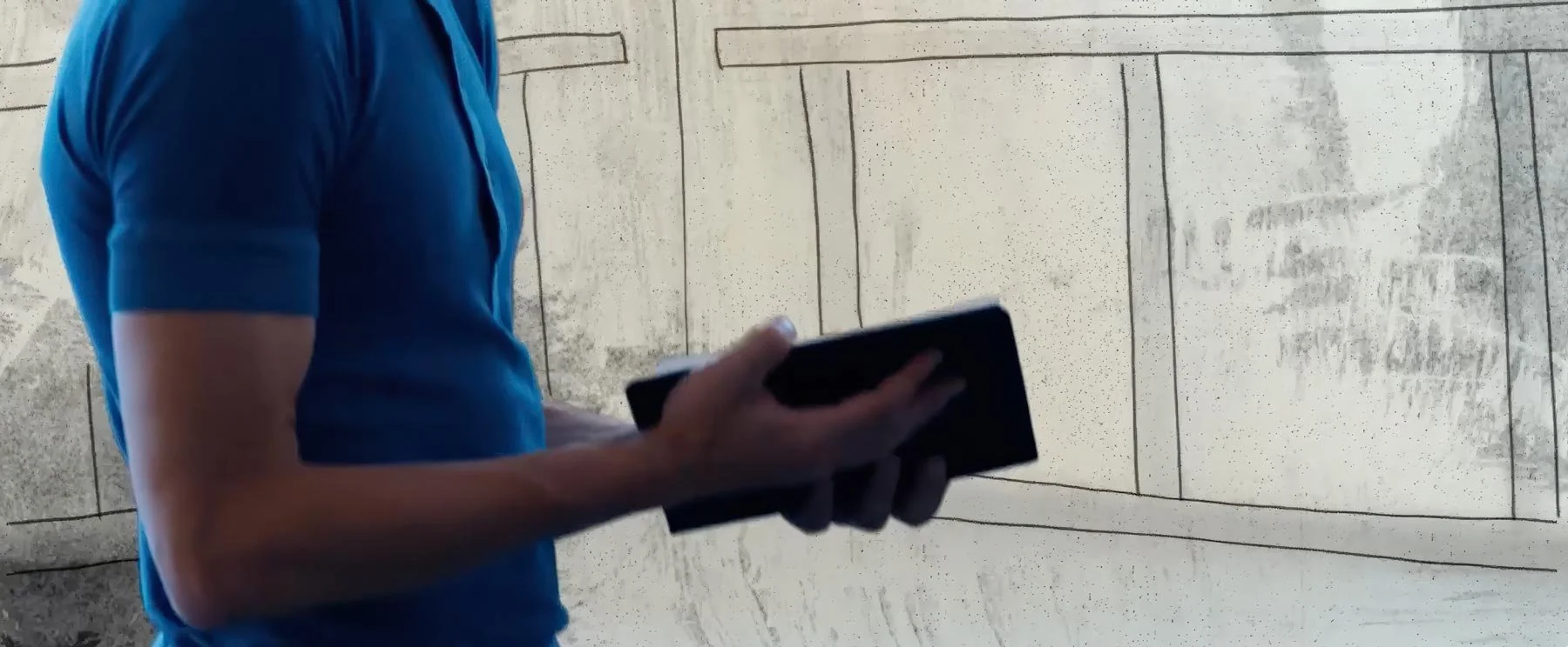 Pontus Lidberg holds his sketchbook against a drawn wall — The Shimmering Asphalt, New York City Ballet.