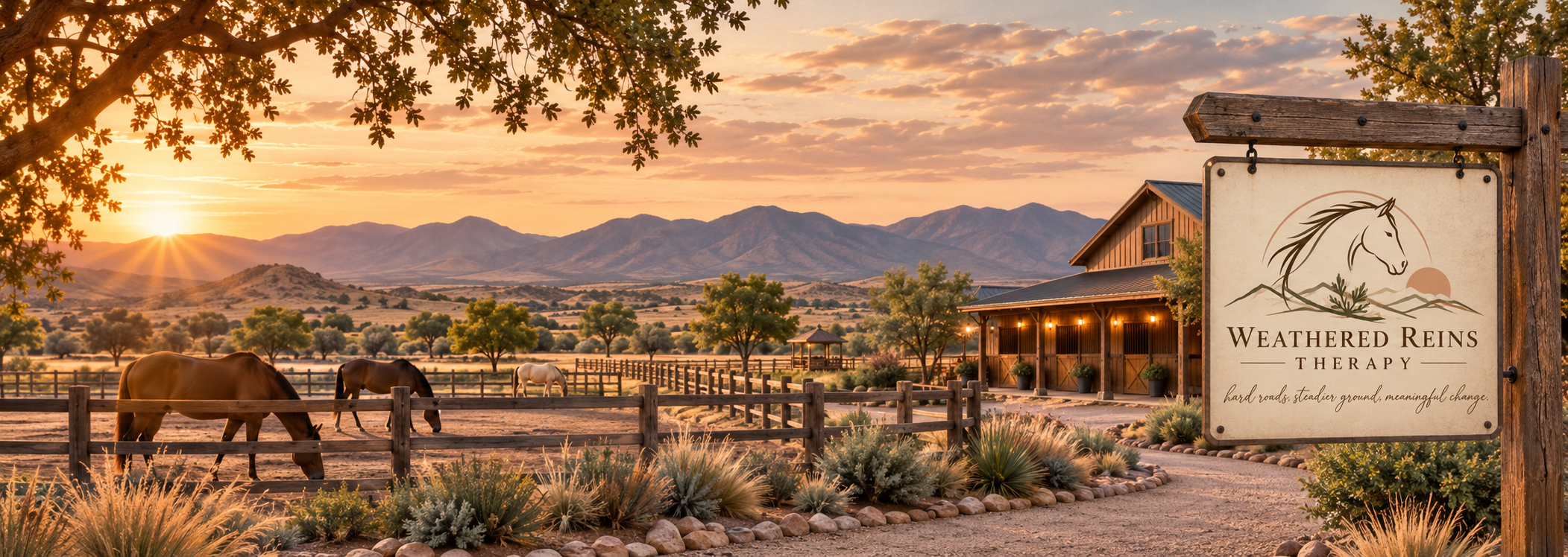 Horses in fenced paddocks at sunset, with a rustic barn, desert landscape, and mountains in the background.