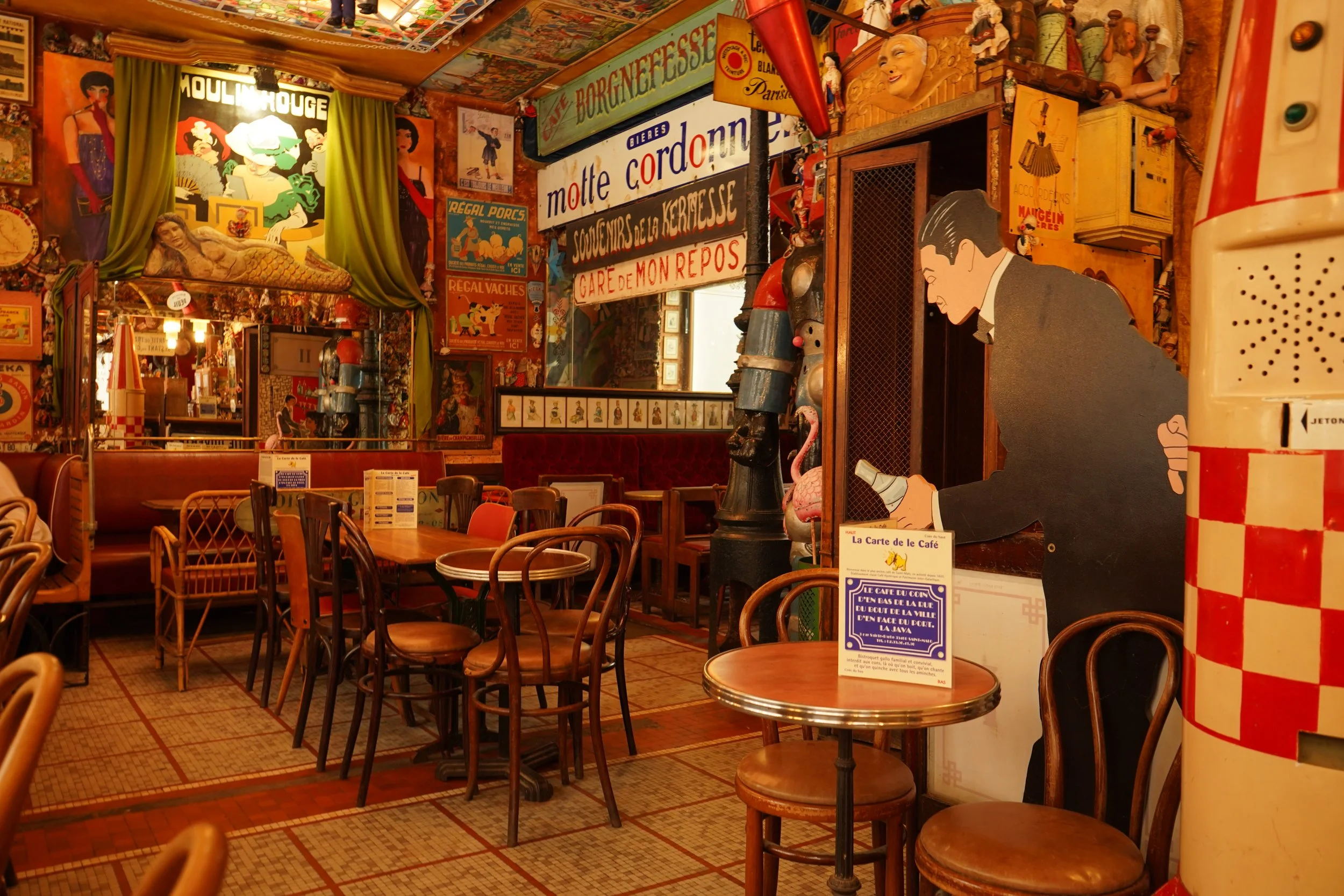 Intérieur d'un restaurant ou café, décor vintage avec affiches, musiciens et personnages en style dessin animé, tables en bois et chaises.