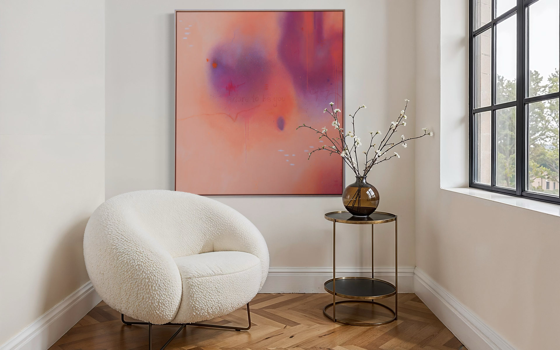 Ein edles, lichtdurchflutes Wohnzimmer mit weißem Bouclé-Sessel, einer runden Beistelltisch aus Metall mit dunklem Glas, einer braunen Vase mit weißen Kirschblüten, einem großformatigen abstrakten Wandbild in warmen Rosétönen, und großen Fenstern