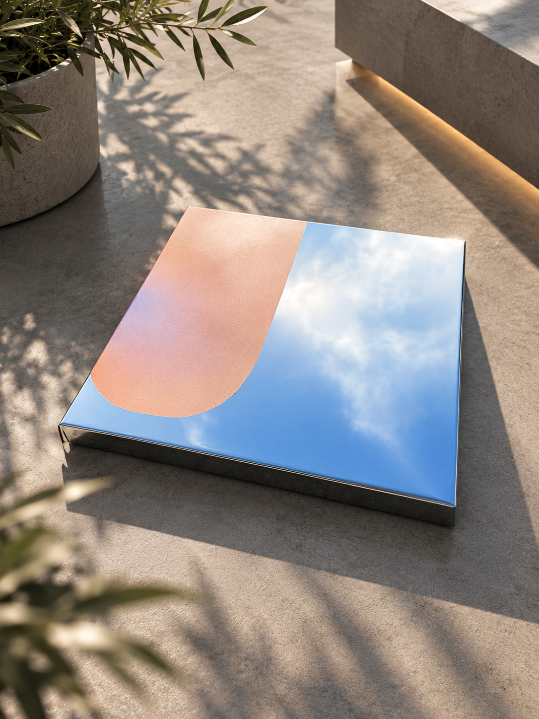 Modernes Spiegel-Artwork mit reflektierendem Himmel und Wolken, auf glattem Boden, neben einer Pflanze