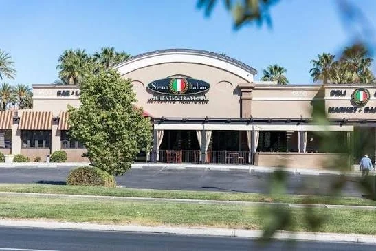 Exterior of a Sierra La Italia restaurant with palm trees and a parking lot in front.