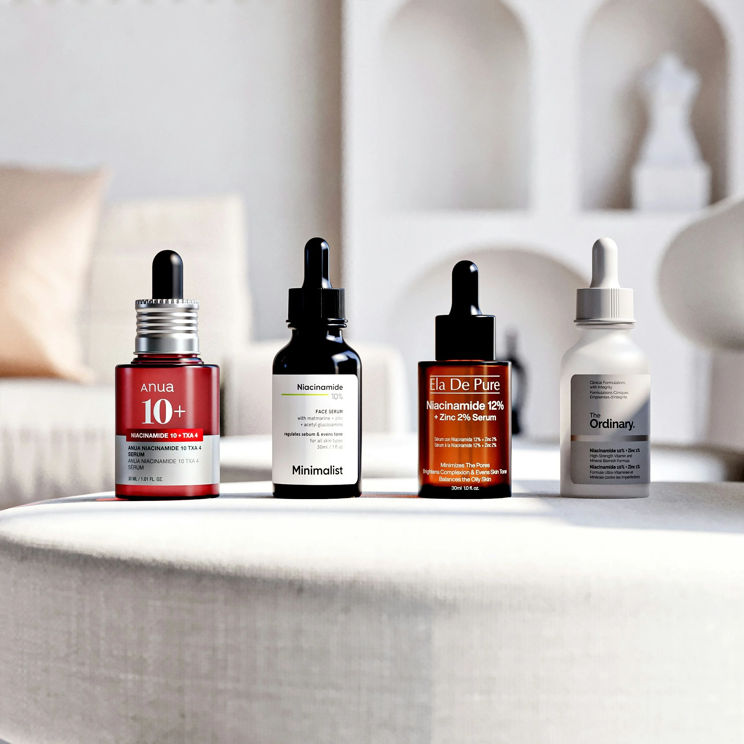 Close-up of skincare serum bottles with dropper caps on a white surface.