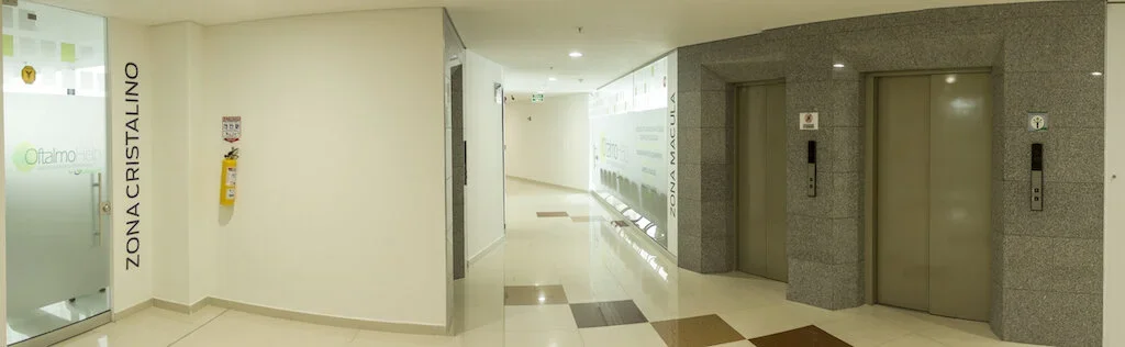 Pasillo en un edificio público con ascensores y señalización en español.