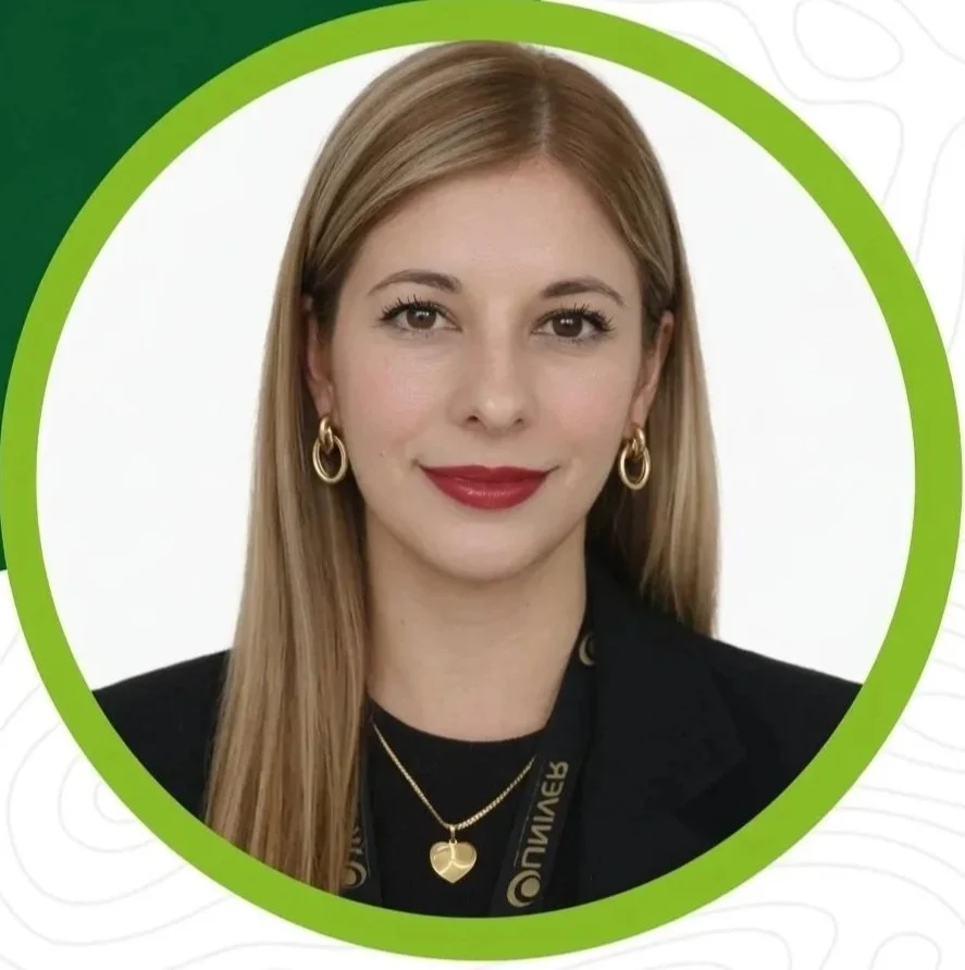 Retrato de una mujer sonriendo con cabello rubio, usando aretes dorados y un collar en un fondo blanco con borde verde.