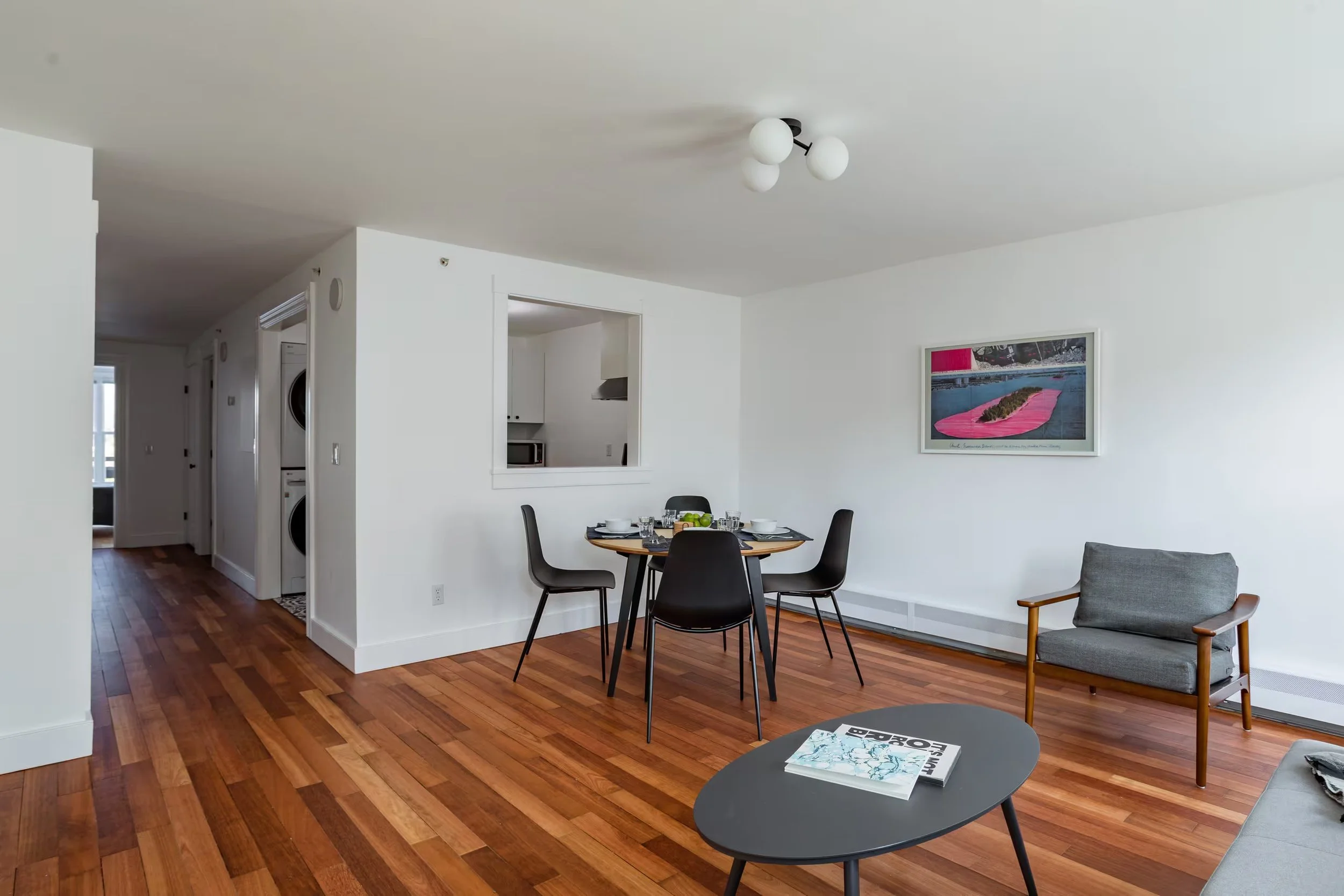 Spacious living and dining room at Within Reach vacation apartment in Catskill, NY, featuring hardwood floors, a dining table for four, and comfortable seating.
