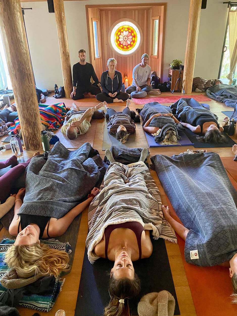 Participants resting under blankets during a guided breathwork session