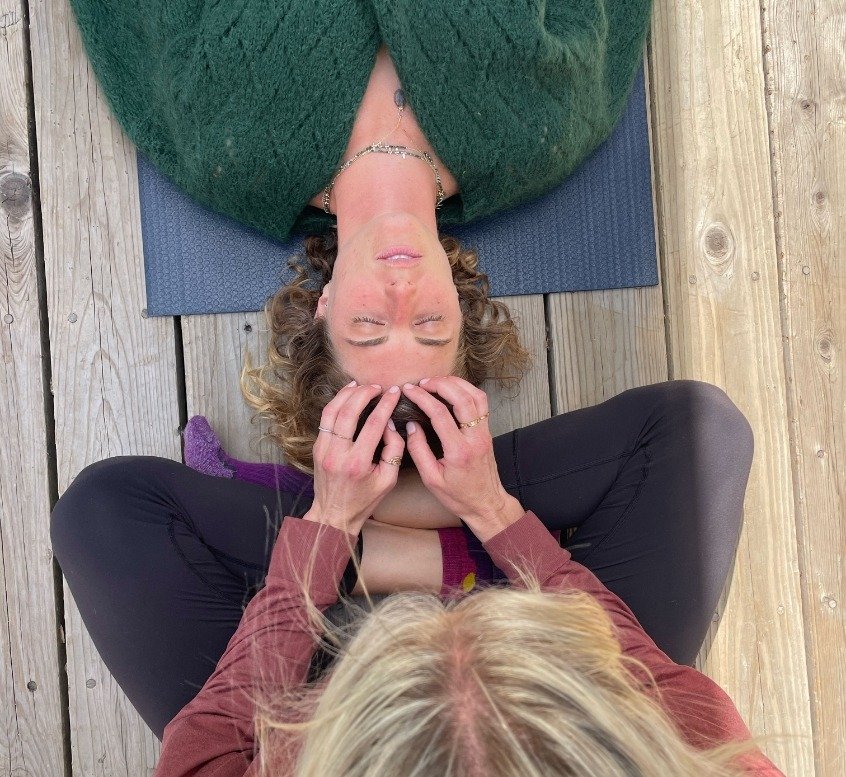 Overhead view of a facilitator cradling a participant's head