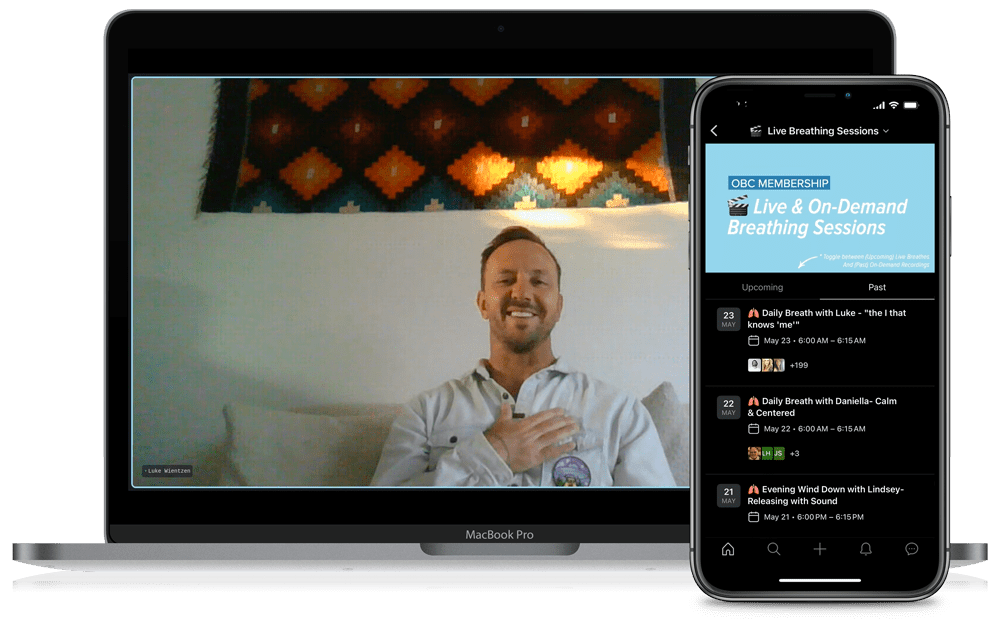A person participating in a virtual breathing session on a MacBook Pro and a smartphone, with a colorful geometric wall hanging in the background.