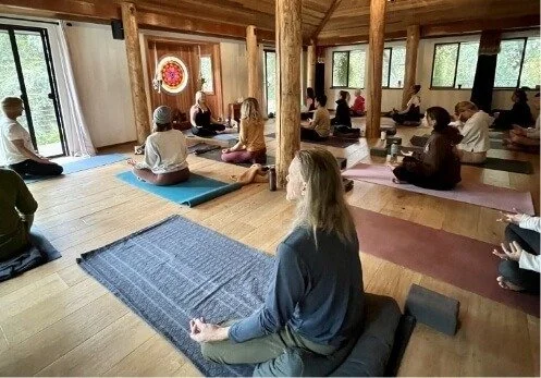 Group of people practicing breathwork in a serene wooden studio with mats, windows, and natural light in Topanga, CA