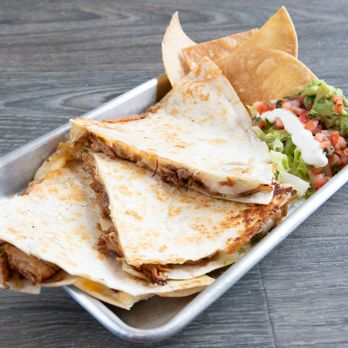 Quesadilla with melted cheese, crispy chips, and a side of salsa and lettuce