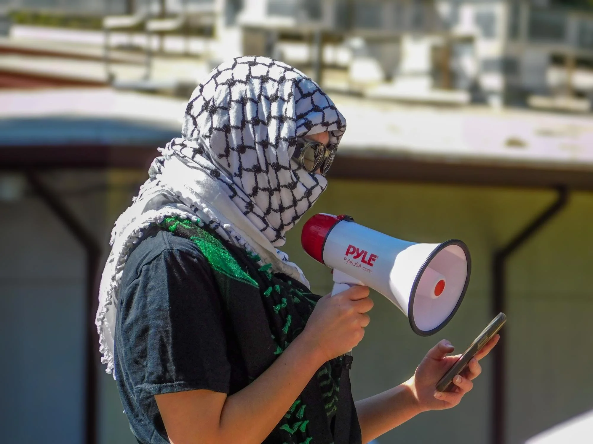  The leader of the protest read off their phone and preached words of encouragement to the other protesters Tuesday, March 11, 2025. The leader had the protesters loud in the library quad, chanting “Free Palestine and Mahmoud Khalil,” as well as “Pro