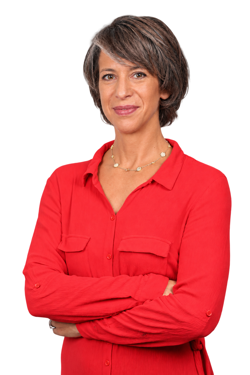 A woman with short, grayish-brown hair, wearing a red button-up shirt with rolled-up sleeves, and a necklace with floral charms.