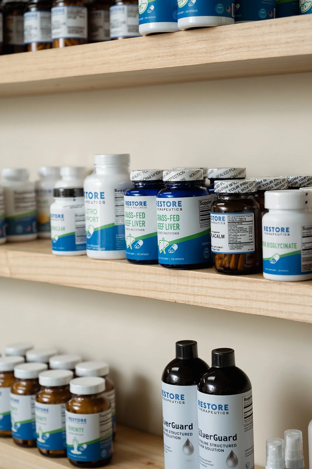Shelves with bottles of dietary supplements, including grass-fed beef liver capsules and SilverGuard solution.