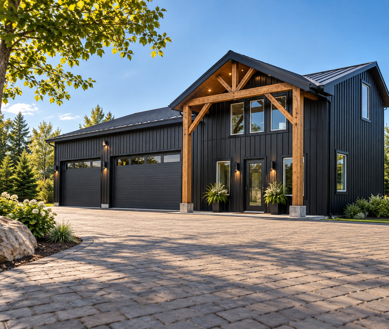 A modern black house with a garage, wooden beams framing the entrance, and a cobblestone driveway, surrounded by greenery and trees on a sunny day.