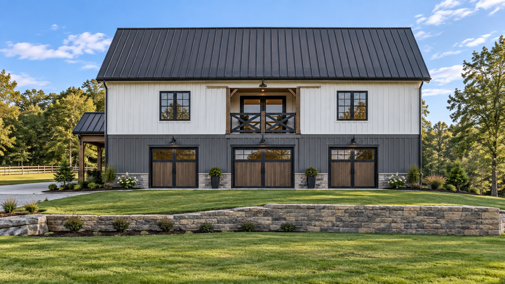 Modern barn-style house with black roof, white and gray siding, and black window frames, surrounded by landscaped yard with green lawn, potted plants, and trees.