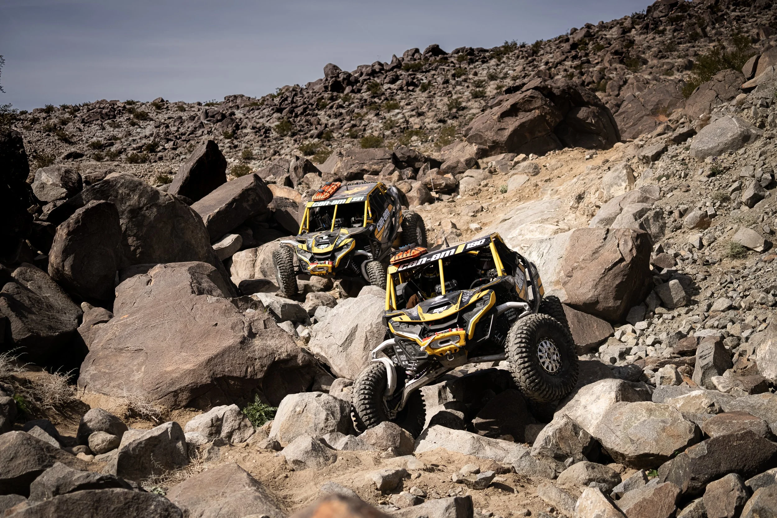Two side-by-sides climbing a rocky canyon at King of the Hammers