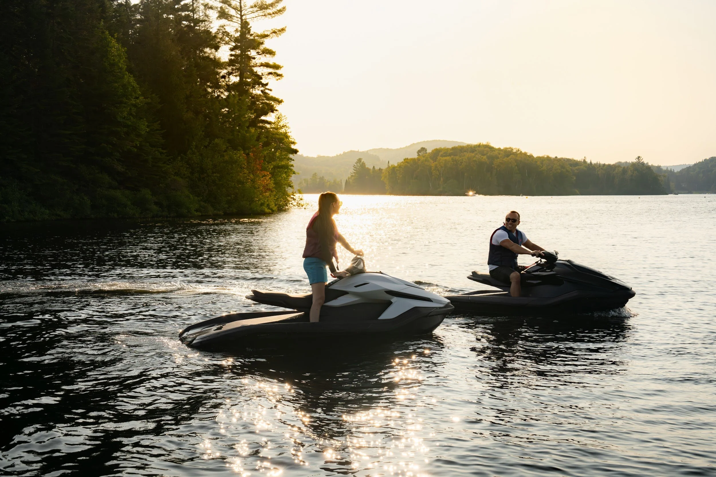 Two riders on Taiga Orcas silhouetted on the lake at golden hour