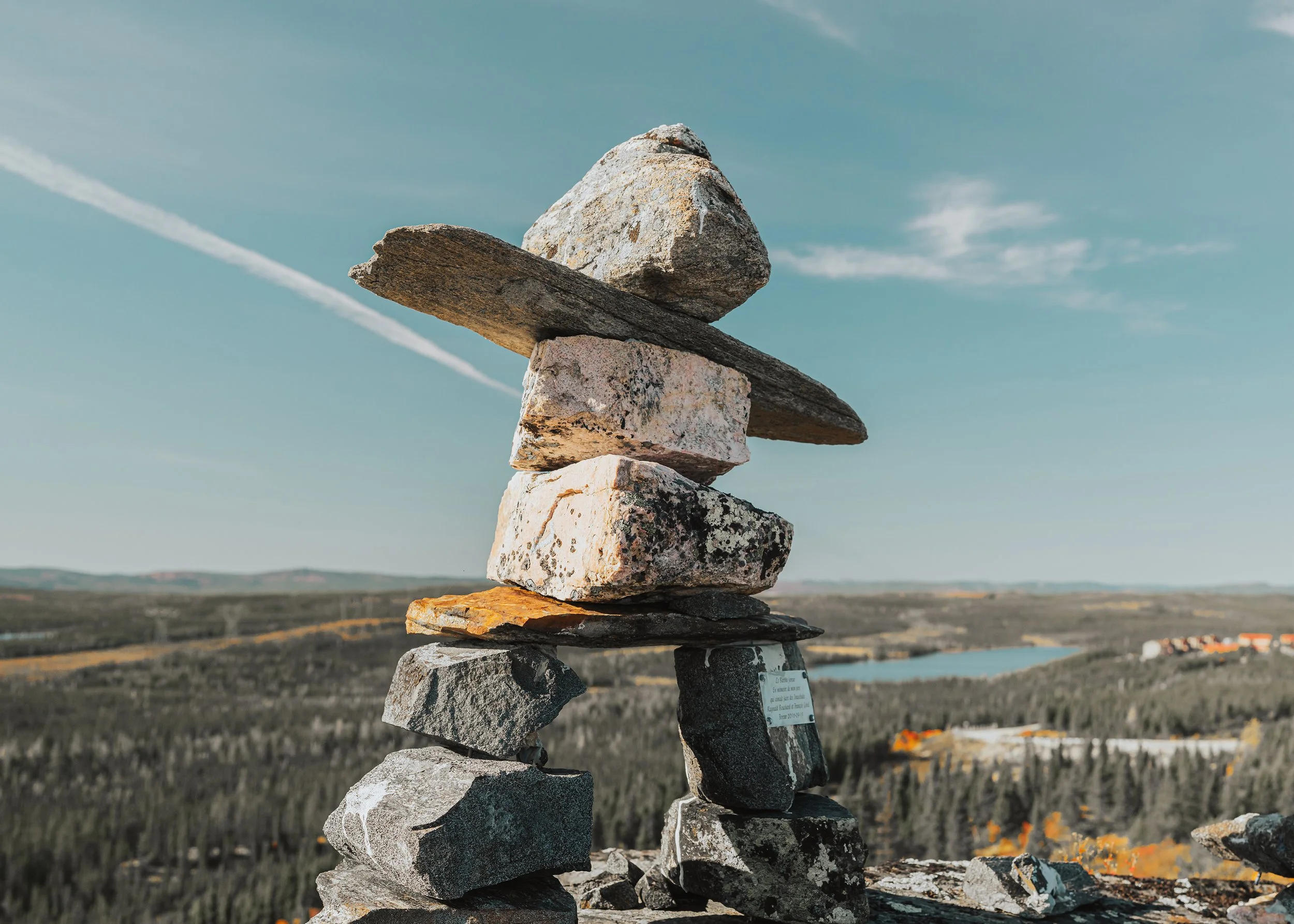 Stone inukshuk overlooking the taiga and a lake
