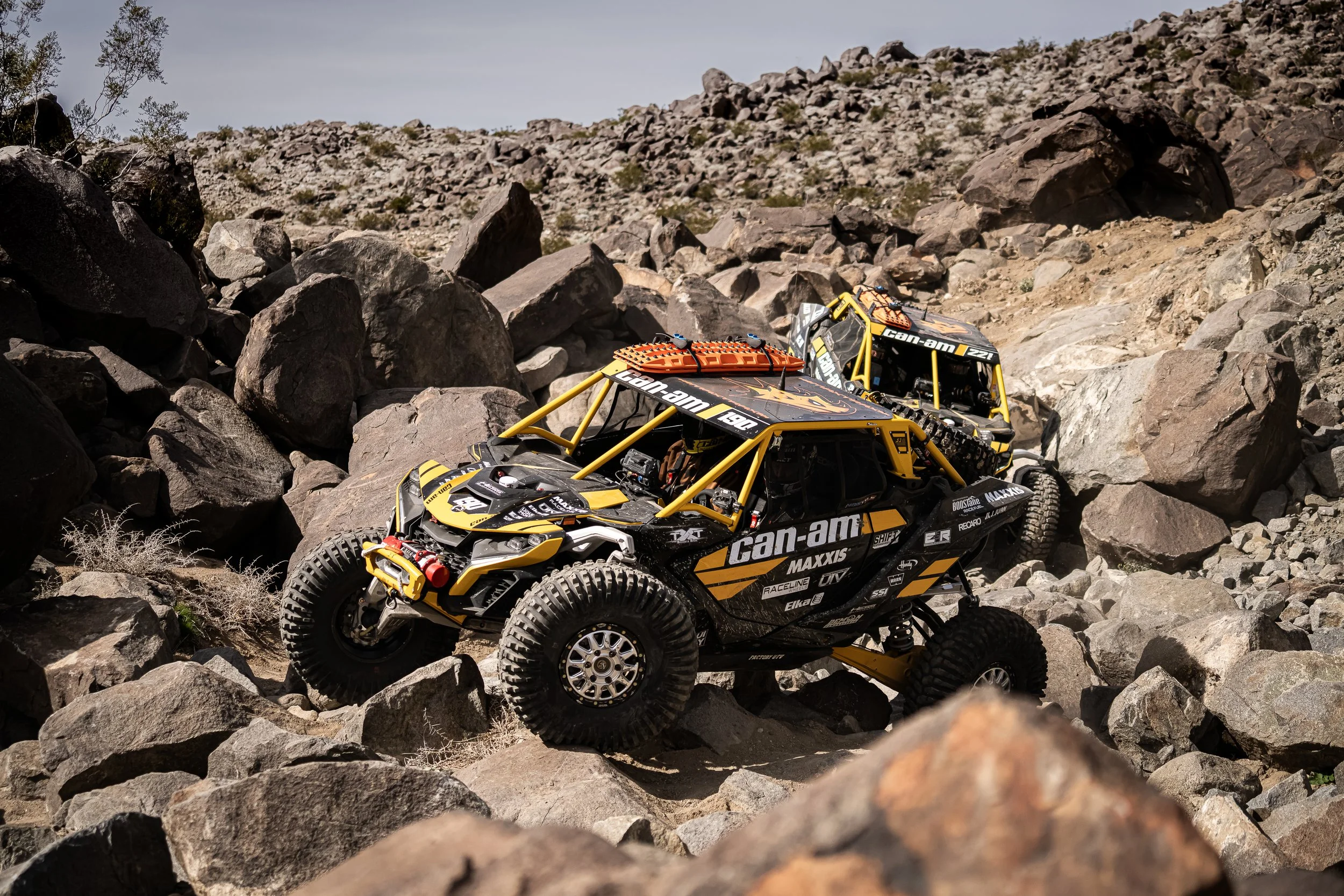 Two Can-Am race cars picking a line through a boulder field at King of the Hammers