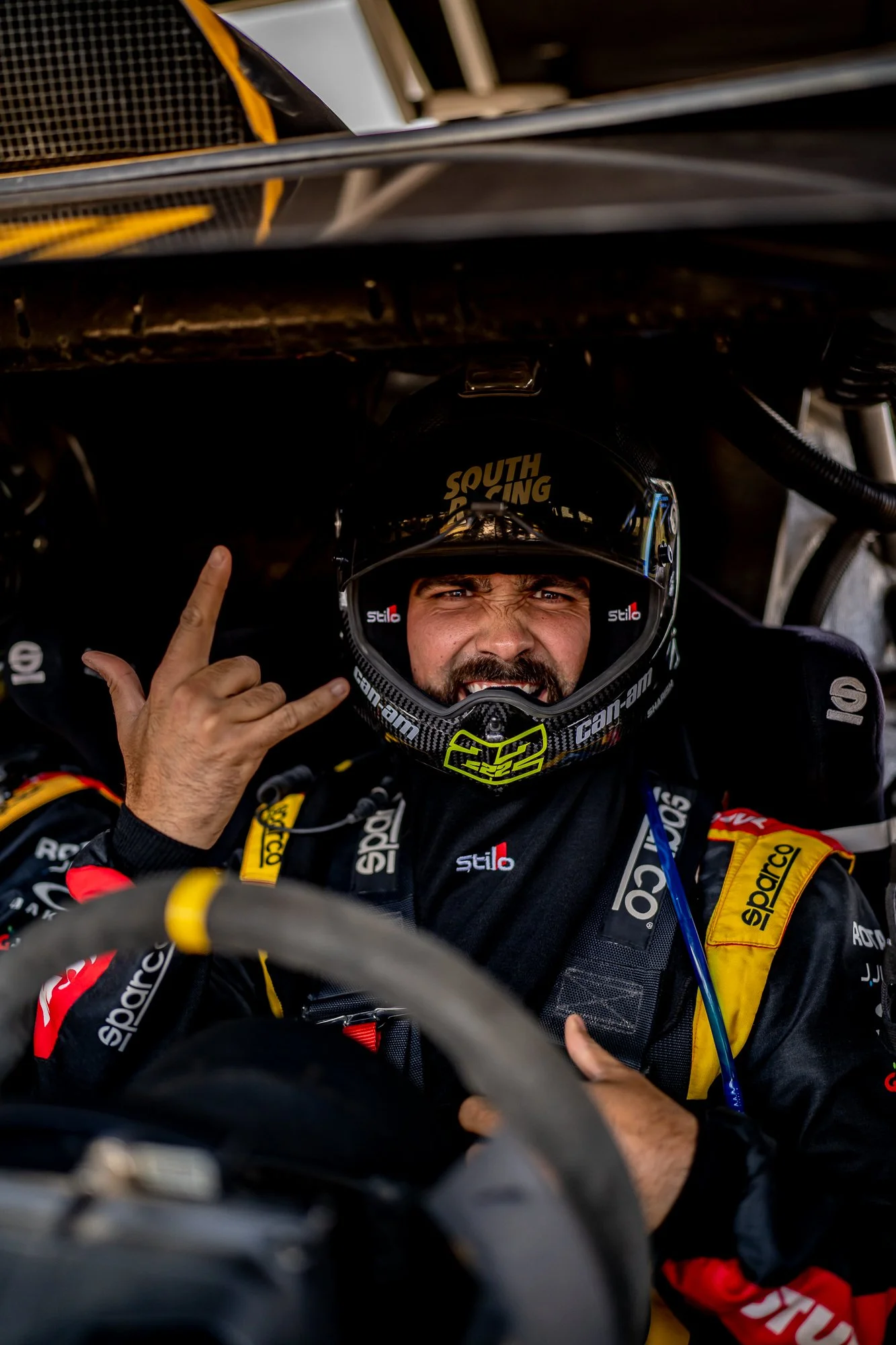 Helmeted driver giving a hand sign from the cockpit