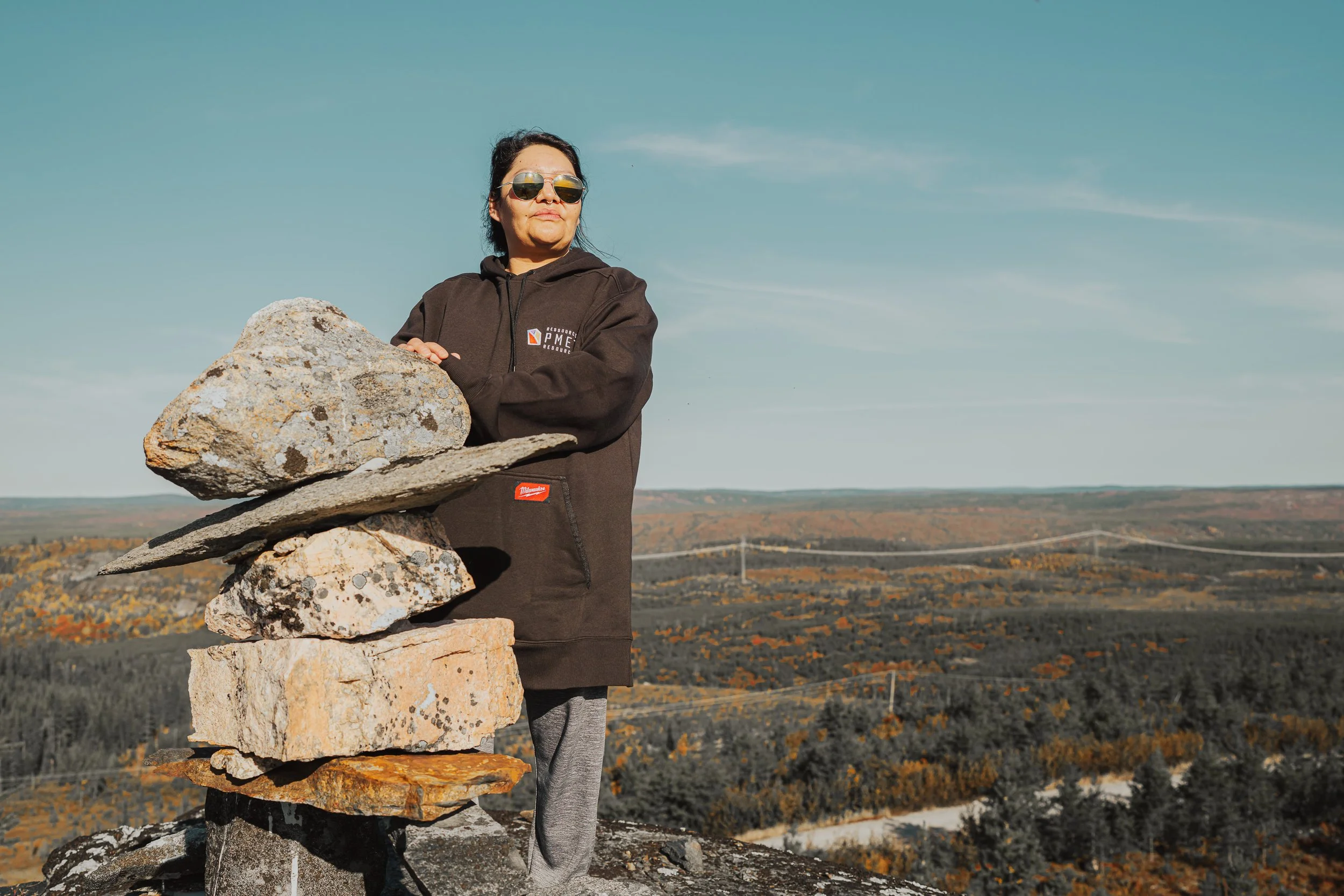 Woman beside a stone inukshuk above the James Bay taiga, from PMET's Day in the Life series
