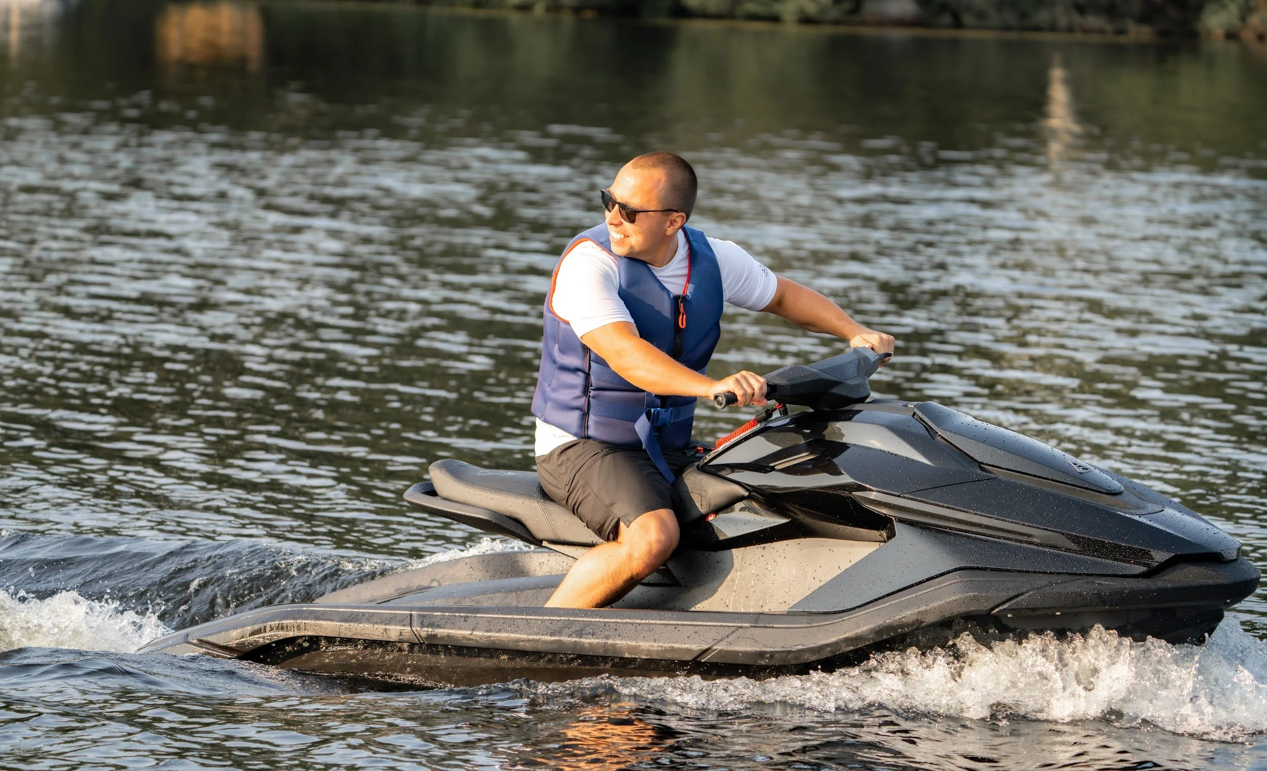 Rider sitting side-saddle on a black Taiga Orca, looking back across the lake