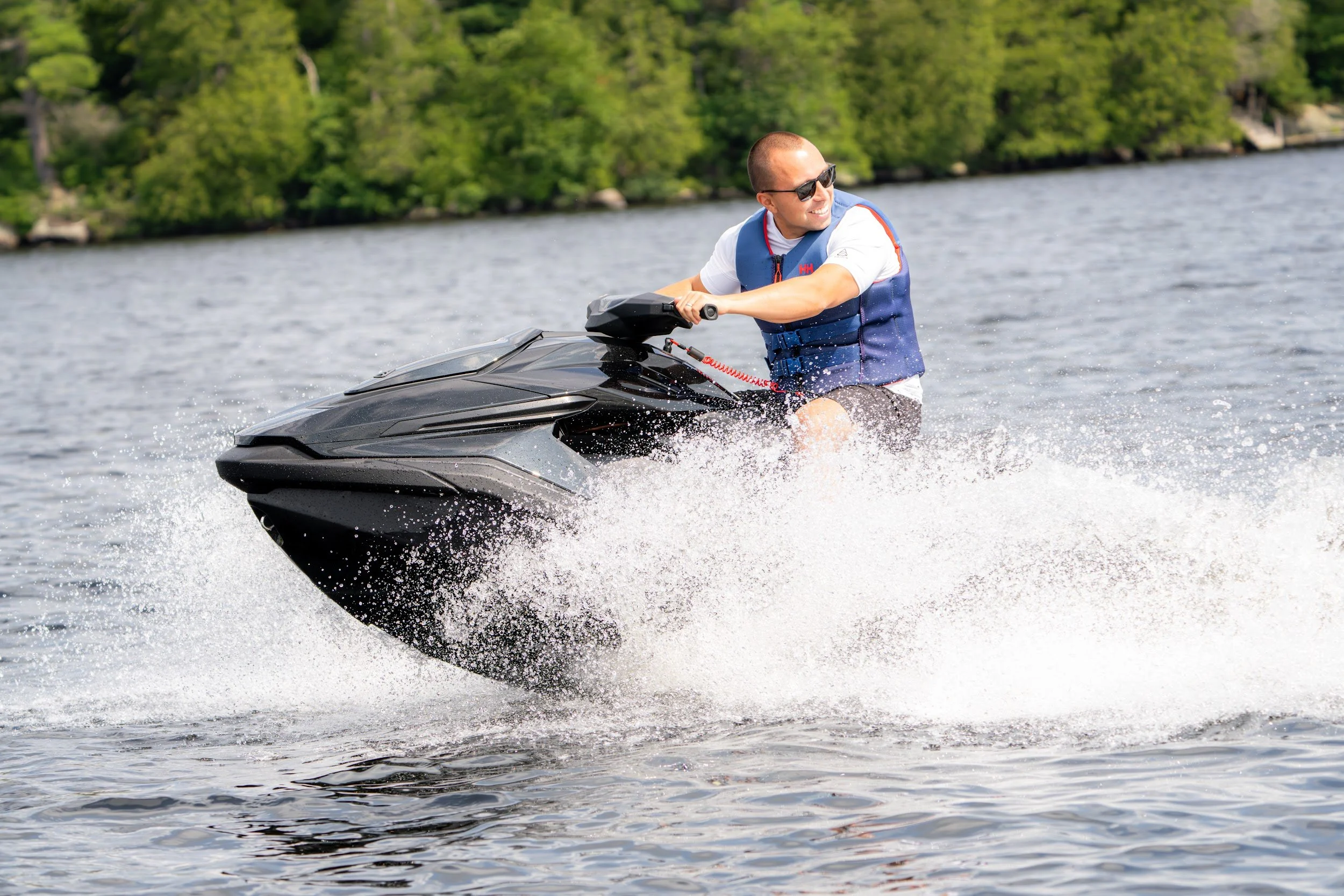 Rider leaning a black Taiga Orca into a turn through white spray