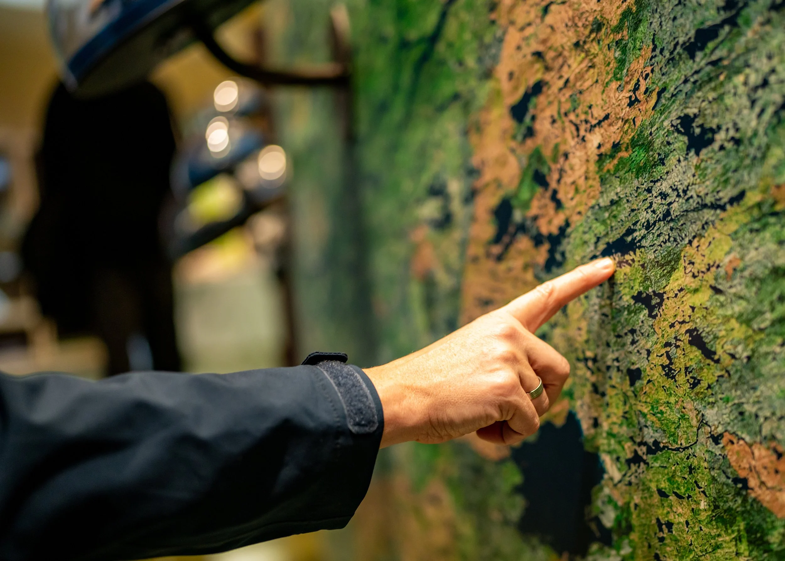 Hand pointing at a spot on a satellite map of James Bay