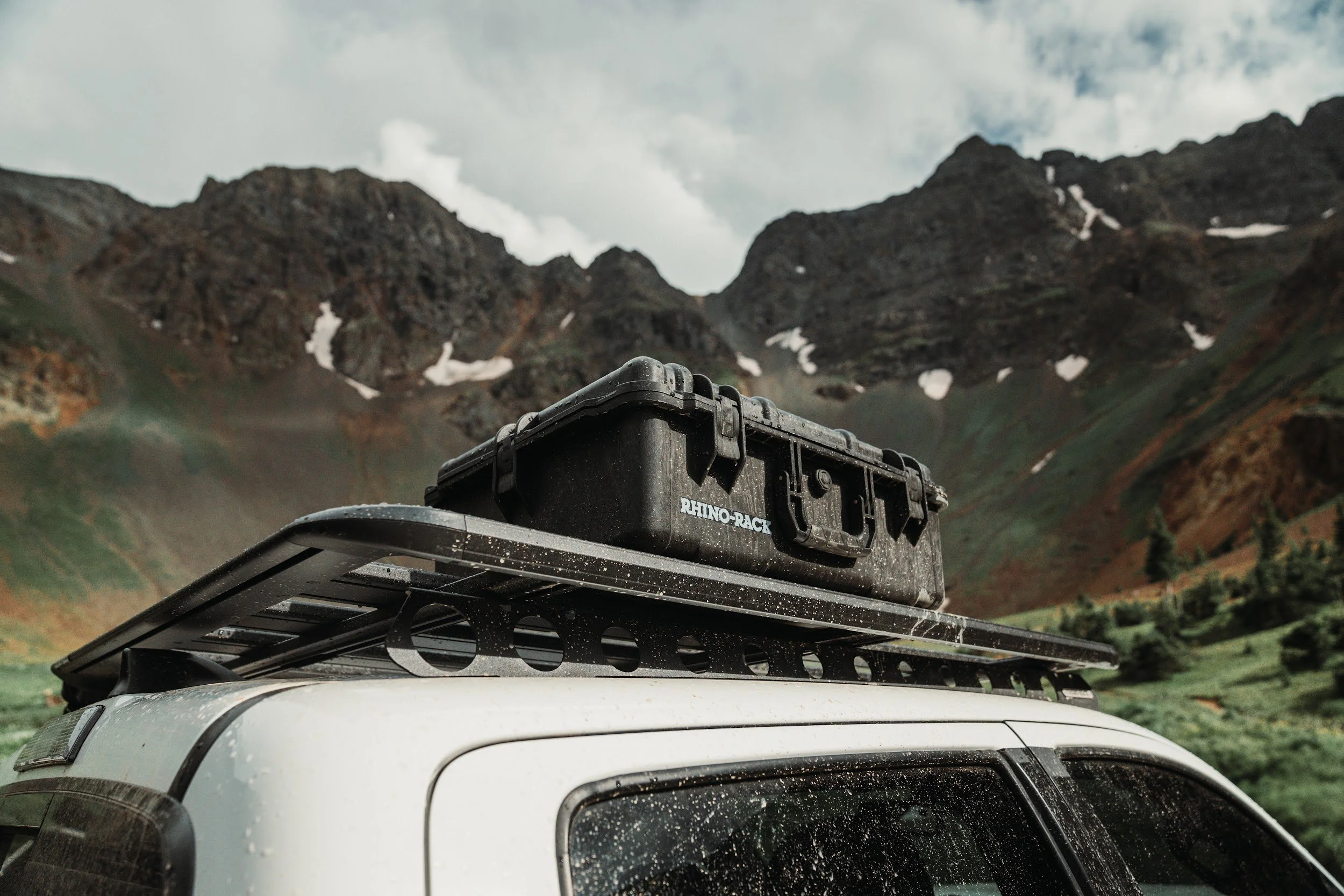 Rhino-Rack gear case mounted on a roof platform, rain on the truck, peaks behind.