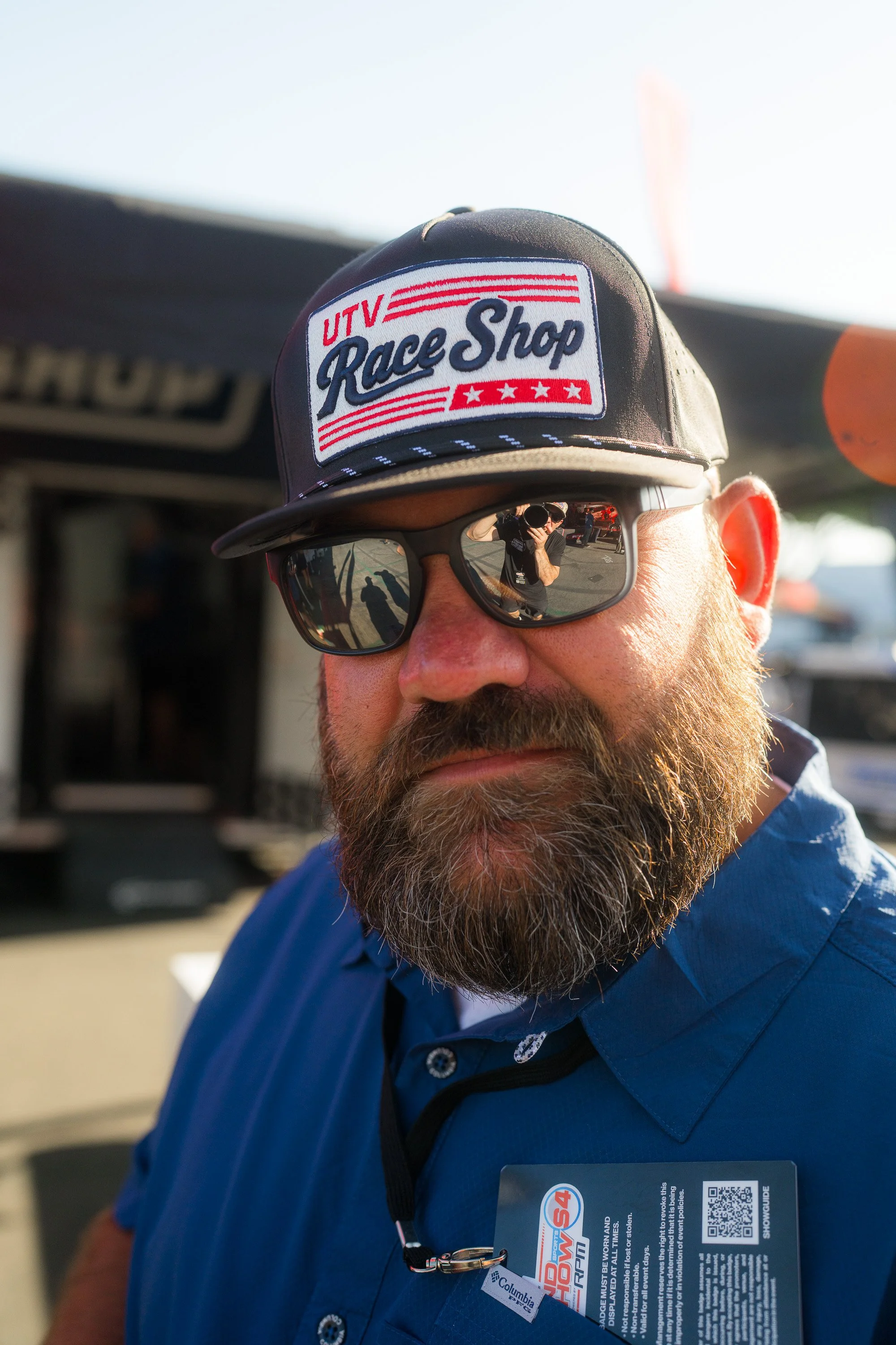 Bearded man in sunglasses wearing a UTV Race Shop patch cap