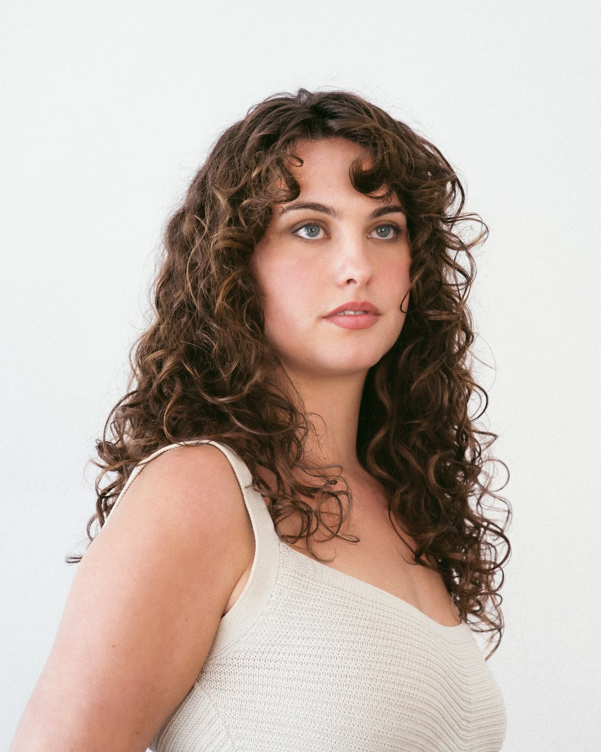 long bouncy natural curly hair, expensive looking brunette hair, dimensional hair colour