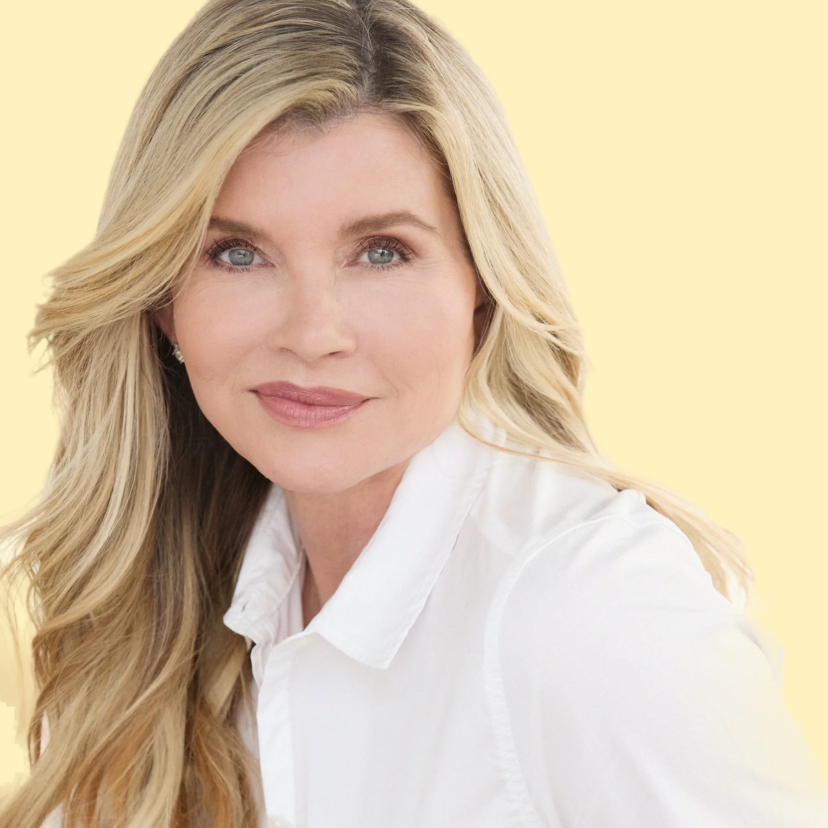 A woman with long blonde hair, wearing a white shirt, smiling slightly against a light yellow background.