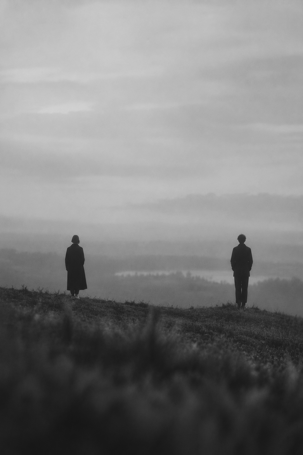 Two people standing apart in a vast landscape