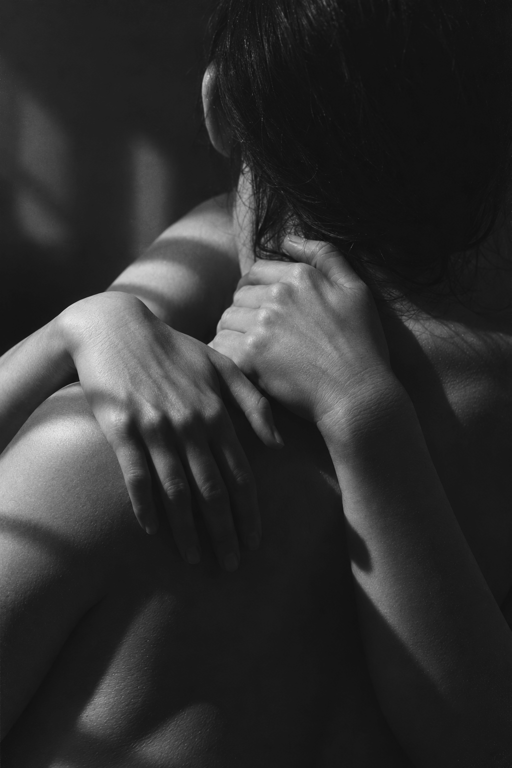 People with their arms wrapped around each other in soft light embrace