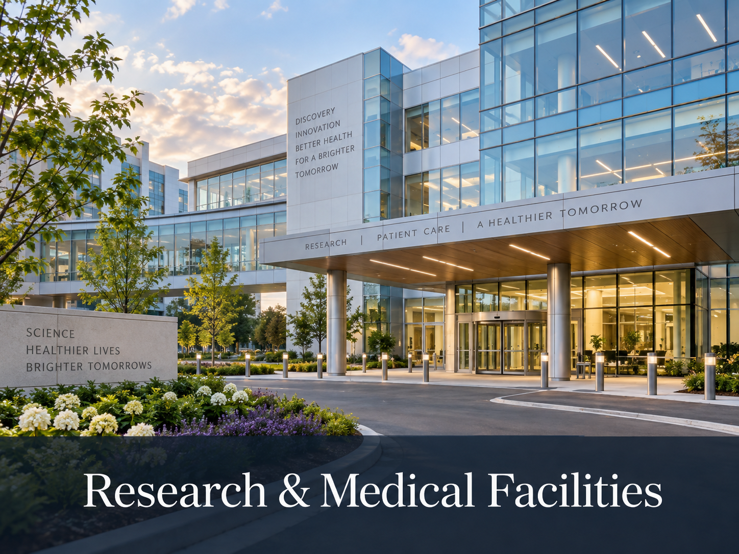 A modern research and medical facility building with glass windows and landscaping, with the sun setting in the background.